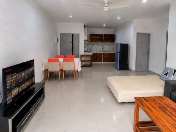 Open-plan living and dining area with kitchen at the back in a 2-bedroom apartment in Sisattanak, Vientiane