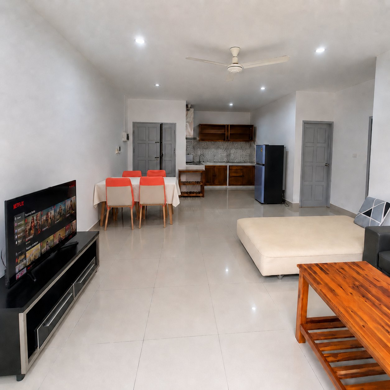 Open-plan living and dining area with kitchen at the back in a 2-bedroom apartment in Sisattanak, Vientiane