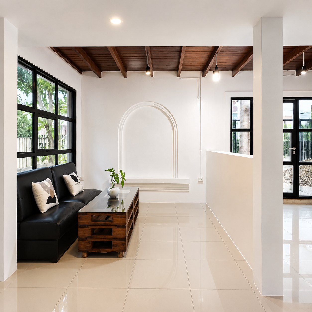Lounge with black leather sofa and arched wall niche in a Vientiane rental villa