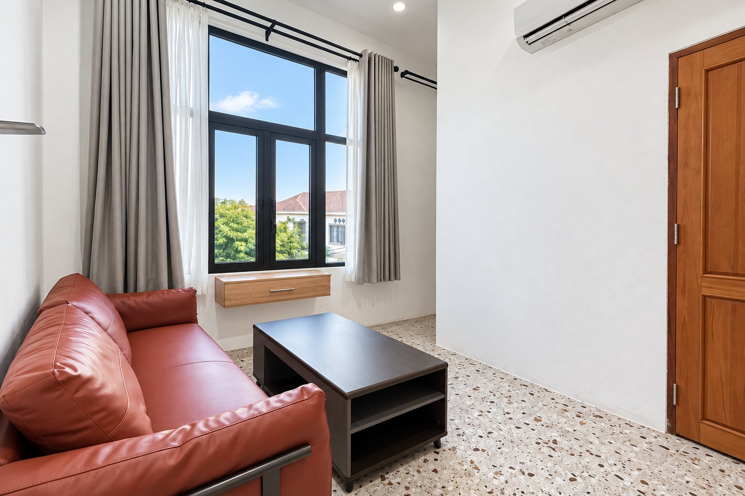 Bright living room with leather sofa and large window – new apartment, city center, Vientiane