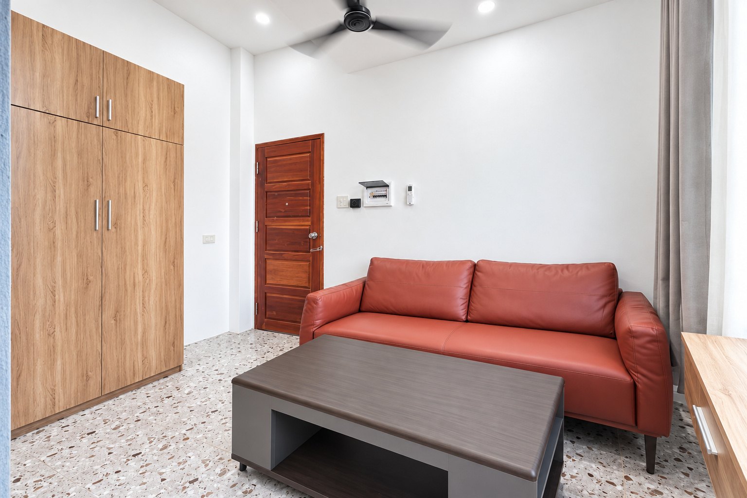 Living room with fitted wardrobe and leather sofa – new apartment, city center, Vientiane