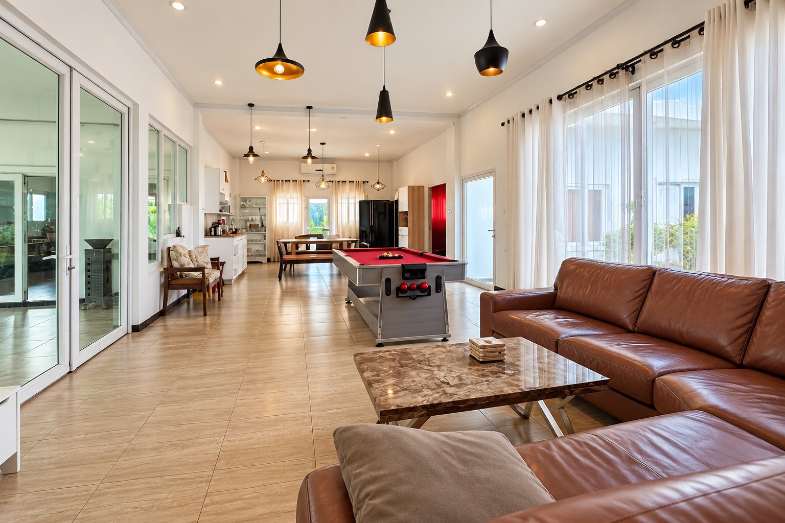 Open-plan living room with leather sofa and pool table – near Khamsavath railway station, Vientiane